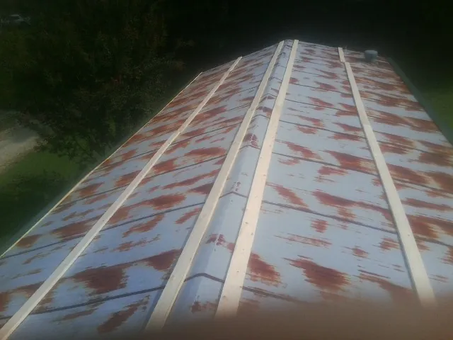 Rusted metal roof panels with new wood purlins before replacement — Storm Damage Roof Repair in Bruington by Roofing Brothers