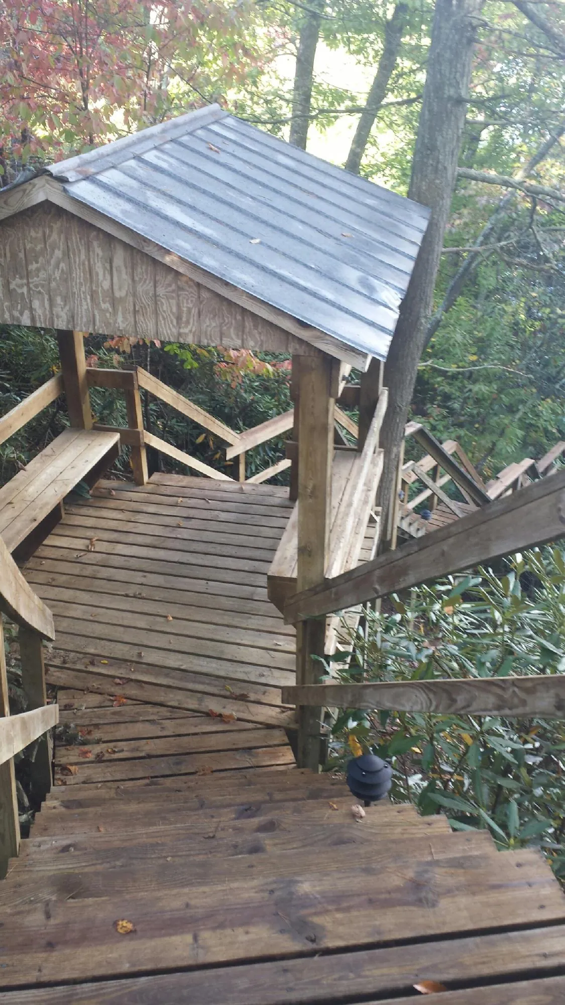 Metal roofed shelter over wooden steps on a wooded walkway — Skylight Repair & Installation work by our crew in Bruington
