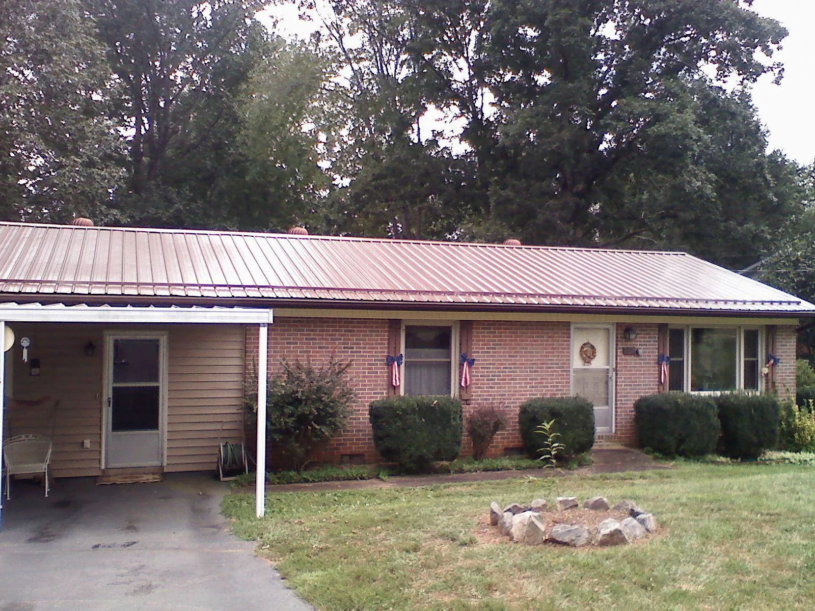 Bronze metal roof and carport on a brick ranch home — Roof Repair work by our crew in Bruington